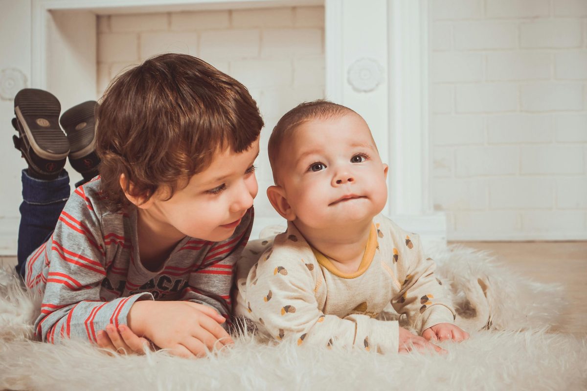 Children happily laying on a rug whilst their parents are at final hearing in children proceedings
