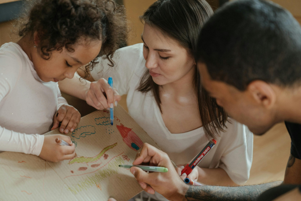Separated parents colouring with their daughter